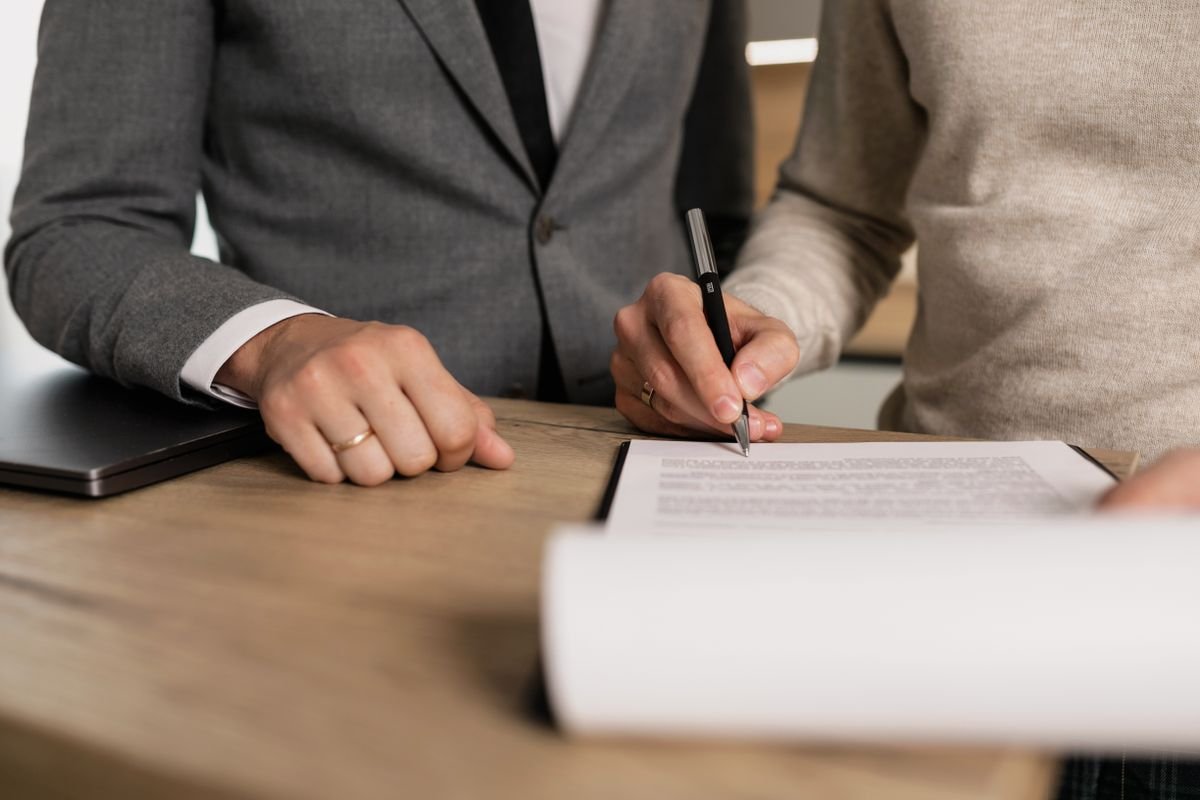 Profissionais assinando um contrato imobiliário em escritório